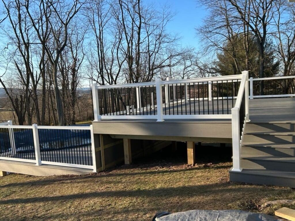 a composite deck with a vinyl railing and a pool