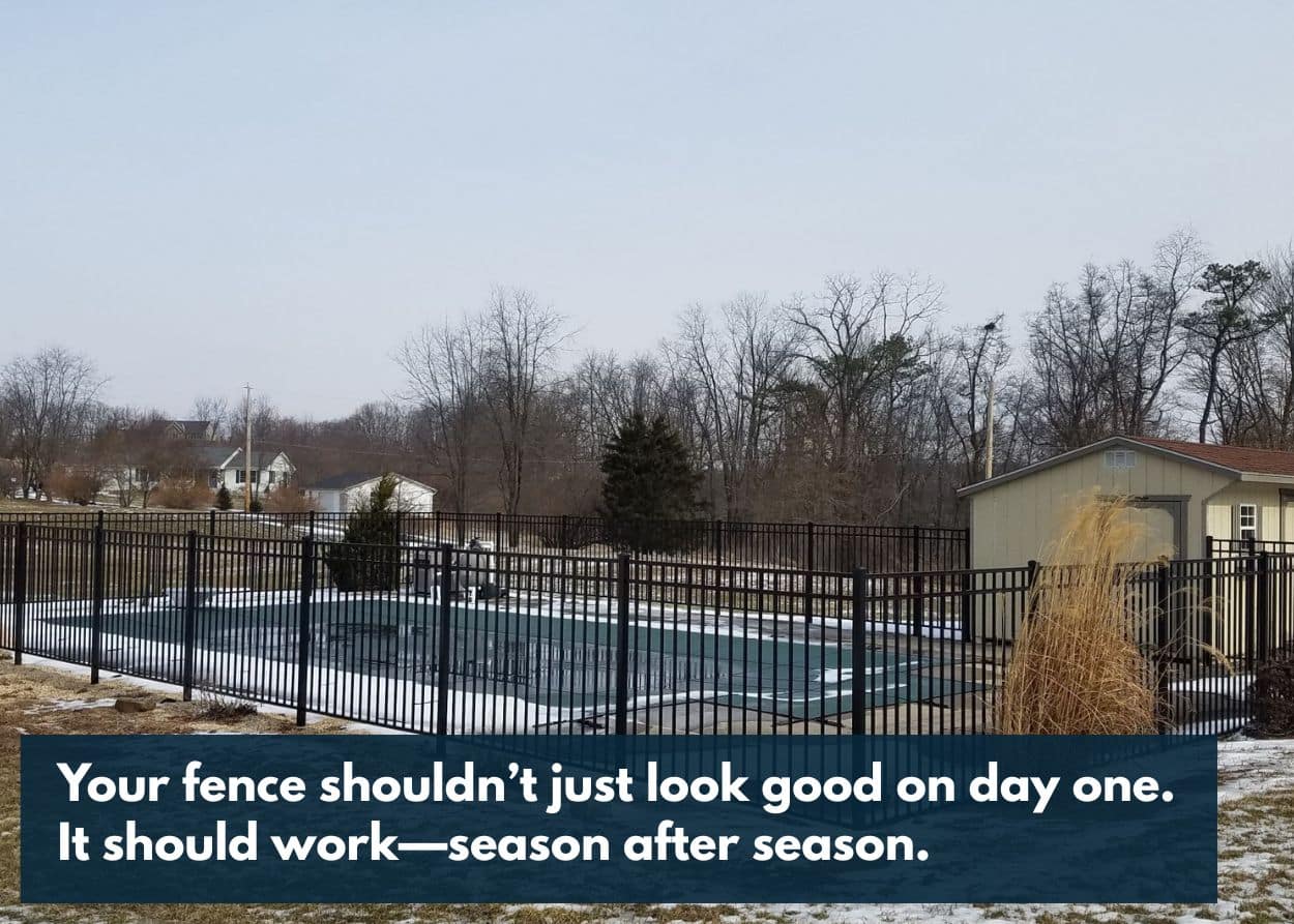 Fence surrounding a pool with snow on the ground