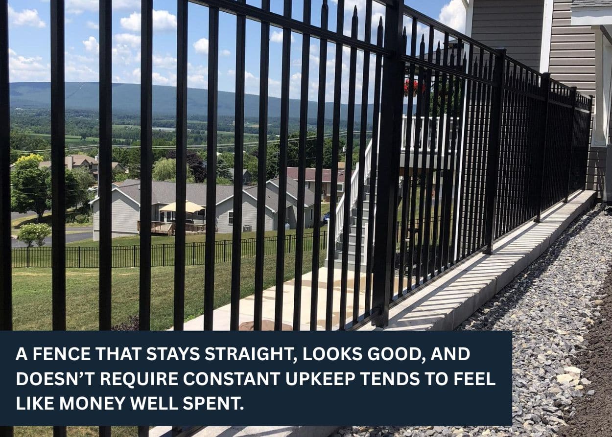 Black aluminum fence installed along a backyard slope with scenic neighborhood view.